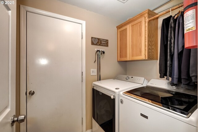 laundry area featuring washing machine and clothes dryer and cabinet space