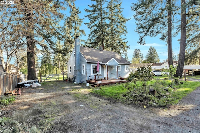 12107 SE Carlton St, Portland, OR 97266 - view of front facade featuring fence, a wooden deck, and a chimney