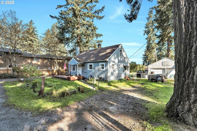 12107 SE Carlton St, Portland, OR 97266 - back of house featuring a chimney, fence, a yard, a wooden deck, and a detached garage