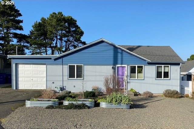 ranch-style home featuring a garage and a shingled roof