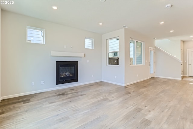 31709 NW Turel Dr, North Plains, OR 97133 - unfurnished living room with a glass covered fireplace, recessed lighting, light wood-style floors, and baseboards