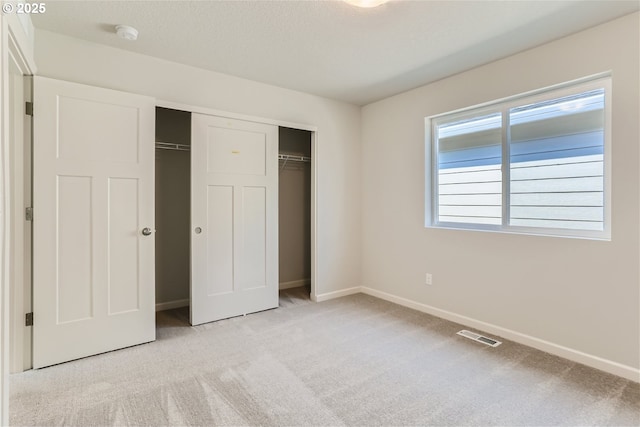 31709 NW Turel Dr, North Plains, OR 97133 - unfurnished bedroom featuring visible vents, baseboards, light colored carpet, a closet, and a textured ceiling