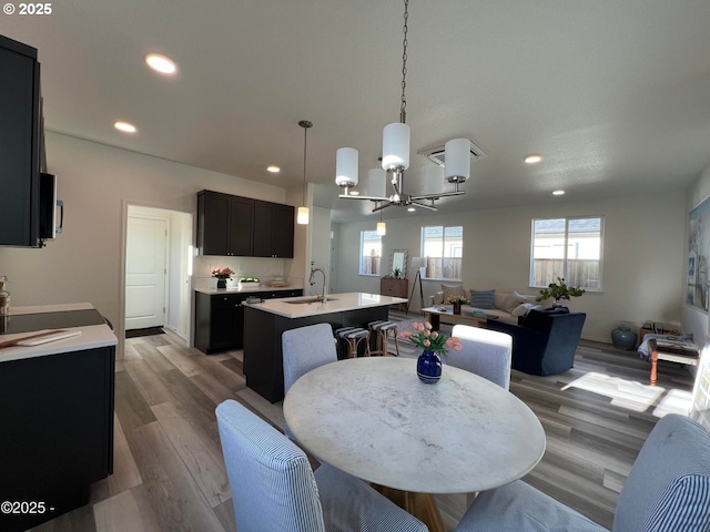 dining space with a chandelier, recessed lighting, and wood finished floors