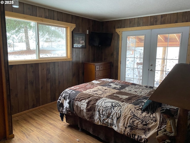 39798 Bear Gulch Rd, Sumpter, OR 97877 - bedroom featuring french doors, wooden walls, access to outside, light wood-style floors, and ornamental molding