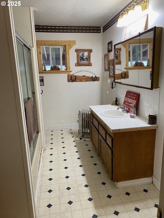 39798 Bear Gulch Rd, Sumpter, OR 97877 - bathroom with radiator, vanity, a stall shower, backsplash, and a textured ceiling
