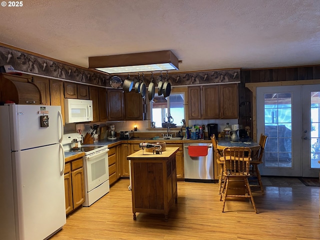 39798 Bear Gulch Rd, Sumpter, OR 97877 - kitchen with white appliances, french doors, a textured ceiling, a center island, and light wood finished floors