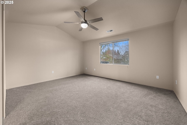 spare room with carpet, visible vents, ceiling fan, and lofted ceiling