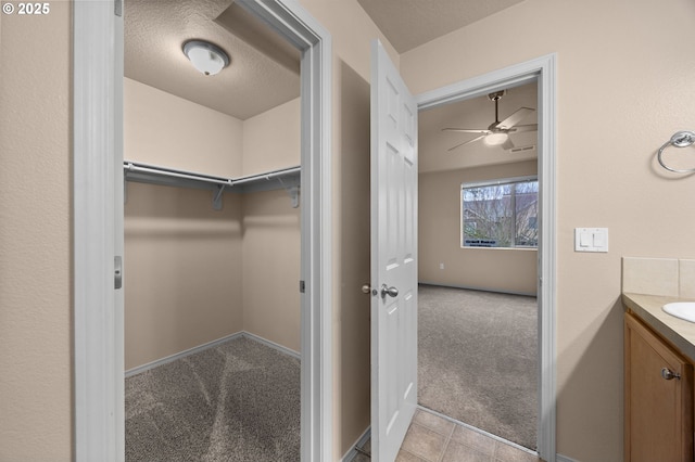 spacious closet featuring light carpet and light tile patterned floors