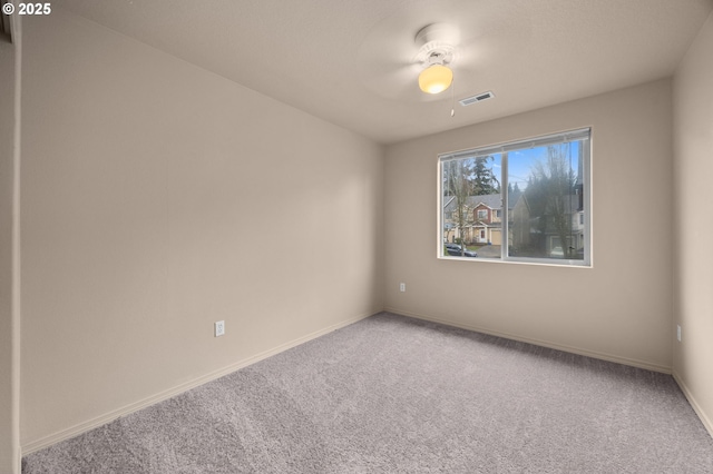 unfurnished room with carpet floors, visible vents, and baseboards