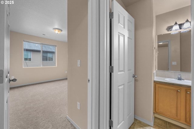 bathroom featuring tile patterned flooring, baseboards, and vanity