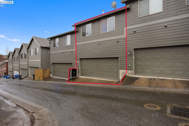 rear view of property featuring a garage and a residential view