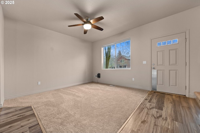 interior space featuring carpet floors, visible vents, ceiling fan, and baseboards