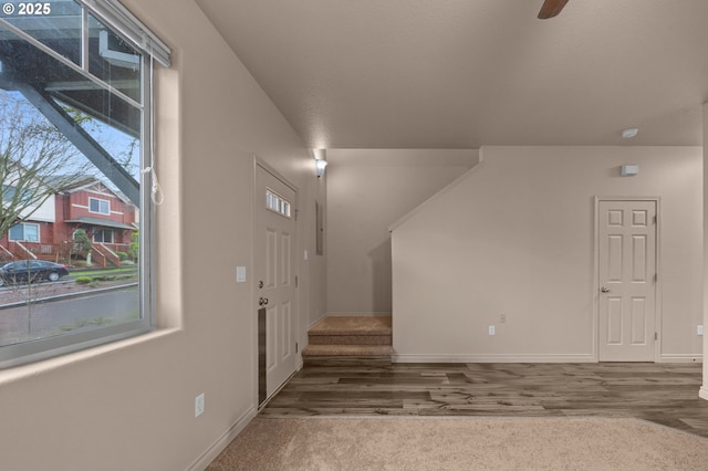 foyer with a ceiling fan, stairs, baseboards, and wood finished floors