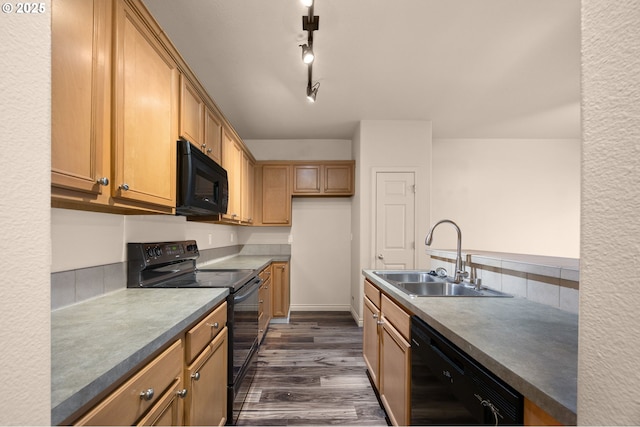 kitchen featuring a sink, backsplash, dark wood-style floors, black appliances, and dark countertops