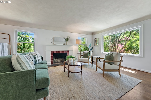 3575 NE Emerson St, Portland, OR 97211 - living room featuring wood finished floors, a brick fireplace, and baseboards