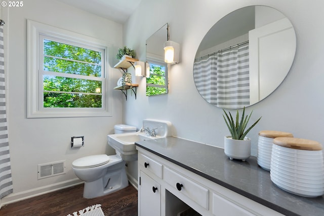 3575 NE Emerson St, Portland, OR 97211 - bathroom with wood finished floors, toilet, vanity, and baseboards