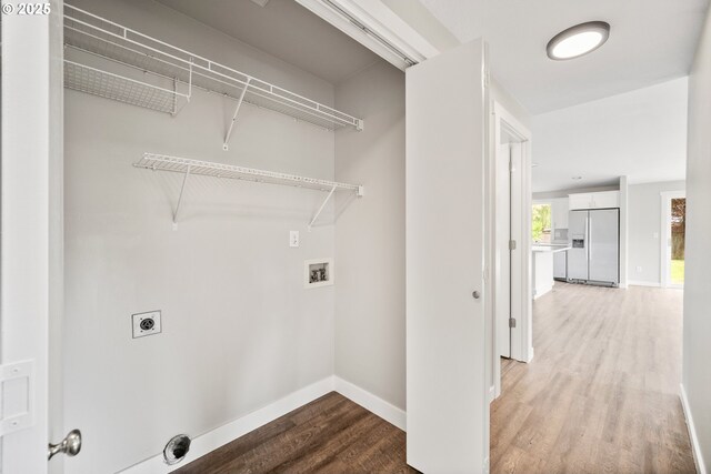 clothes washing area featuring laundry area, hookup for a washing machine, baseboards, electric dryer hookup, and light wood-type flooring