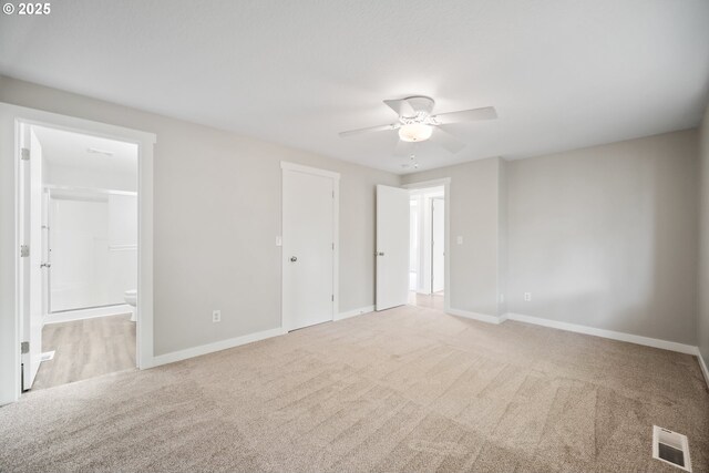 unfurnished room featuring carpet floors, a ceiling fan, baseboards, and visible vents