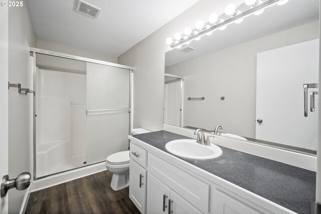 full bath with visible vents, a shower stall, wood finished floors, vanity, and toilet