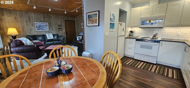 5840 Hacienda Ave, Lincoln City, OR 97367 - dining area featuring track lighting, dark wood-style flooring, and wooden walls
