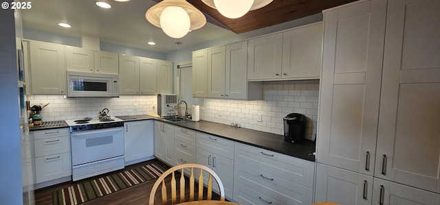 5840 Hacienda Ave, Lincoln City, OR 97367 - kitchen with white appliances, dark countertops, a sink, backsplash, and recessed lighting