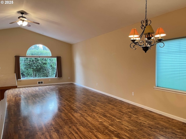 empty room with dark hardwood / wood-style flooring, ceiling fan with notable chandelier, and lofted ceiling