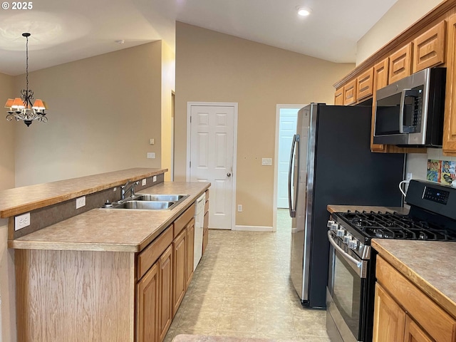 kitchen featuring sink, hanging light fixtures, stainless steel appliances, a notable chandelier, and an island with sink