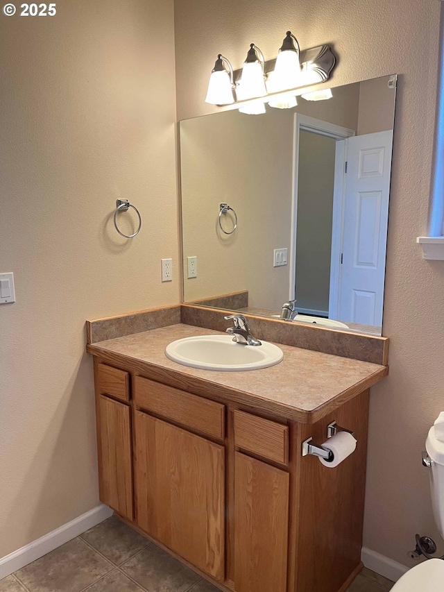 bathroom featuring tile patterned flooring, vanity, and toilet