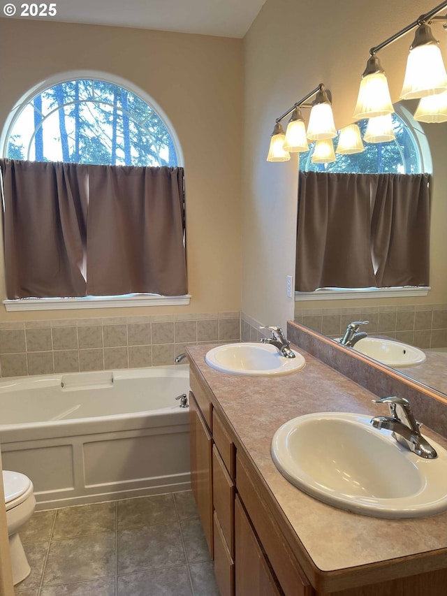 bathroom featuring a tub, tile patterned flooring, vanity, and toilet