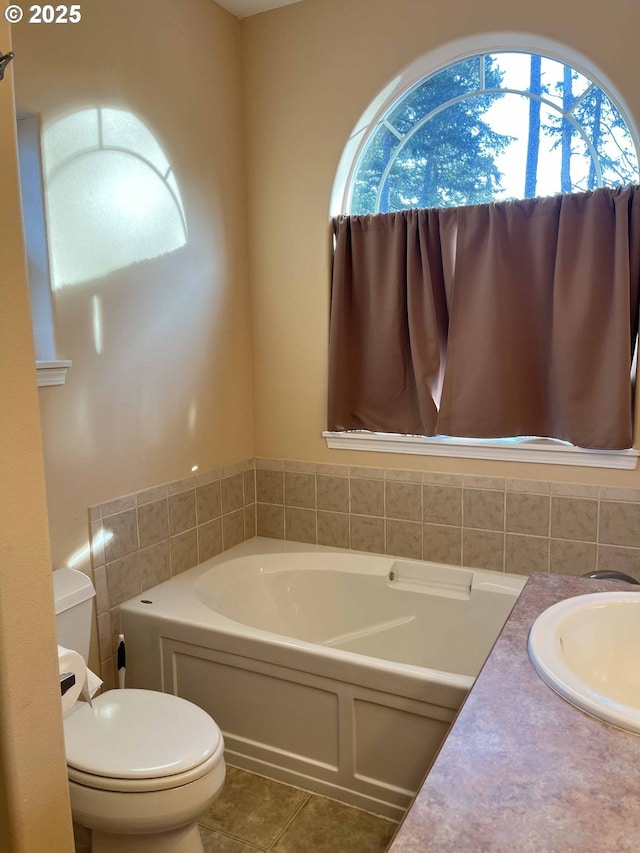 bathroom with tile patterned flooring, vanity, toilet, and a bathing tub