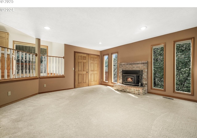 unfurnished living room with a wood stove and light carpet