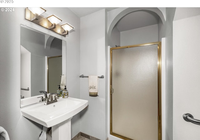 bathroom with an enclosed shower and sink