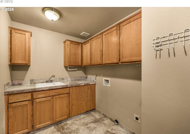 clothes washing area featuring sink, cabinets, and washer hookup