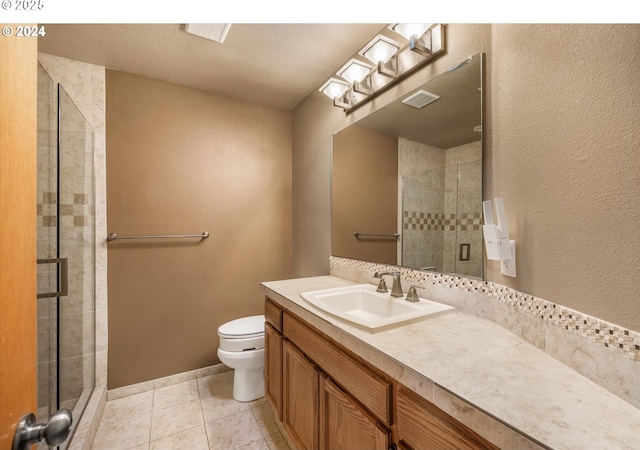 bathroom featuring tile patterned floors, vanity, an enclosed shower, and toilet