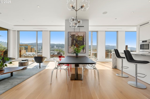 dining area with floor to ceiling windows, visible vents, light wood finished floors, and an inviting chandelier