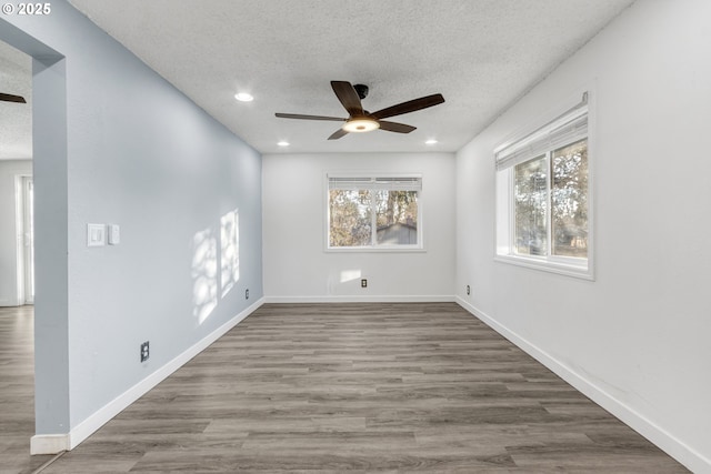 empty room featuring ceiling fan, hardwood / wood-style floors, and a textured ceiling