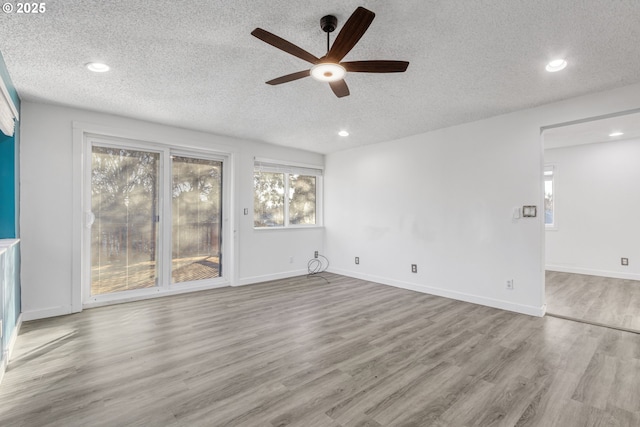 unfurnished living room featuring light wood-type flooring, a textured ceiling, and ceiling fan