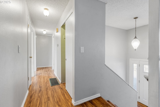 hall featuring hardwood / wood-style floors and a textured ceiling