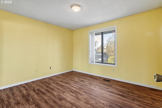 empty room featuring hardwood / wood-style floors and a textured ceiling