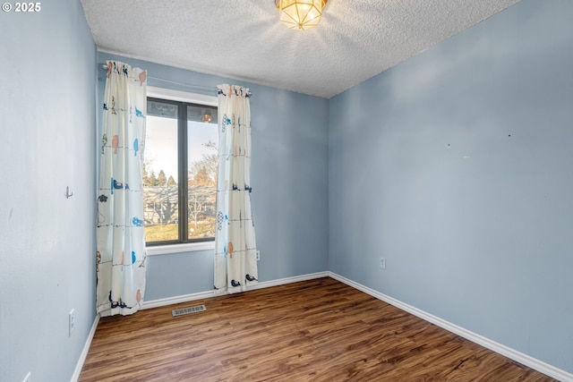 spare room with hardwood / wood-style flooring and a textured ceiling