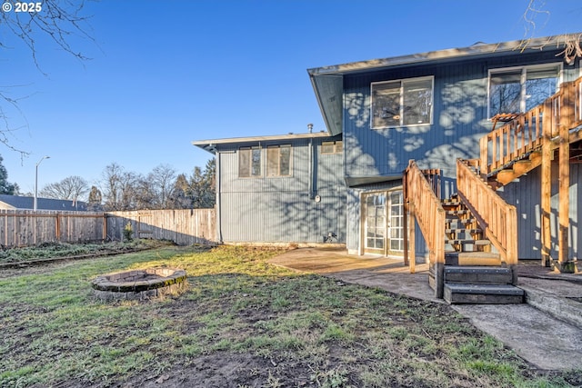 back of house with a patio area, a lawn, and a fire pit