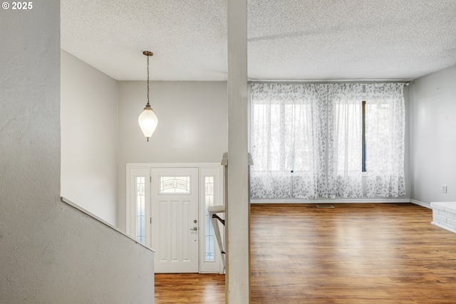 entrance foyer with plenty of natural light, a textured ceiling, and hardwood / wood-style floors