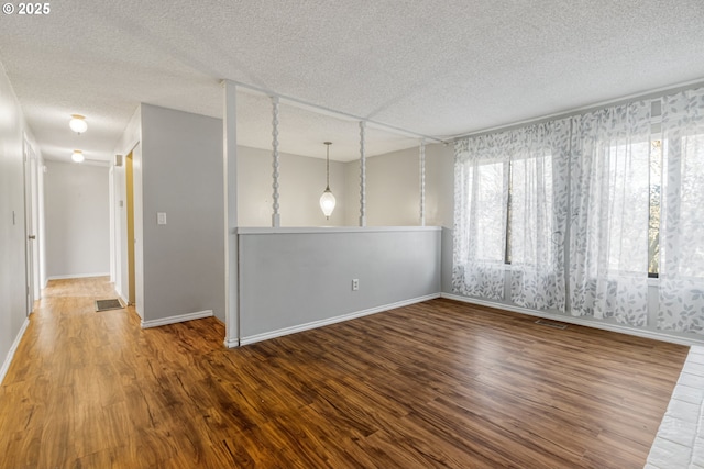 empty room with hardwood / wood-style floors and a textured ceiling