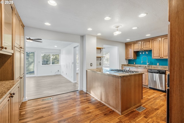 kitchen featuring kitchen peninsula, sink, light hardwood / wood-style flooring, and stainless steel appliances