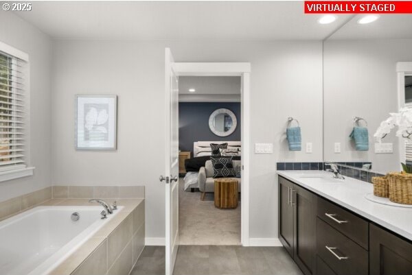 bathroom featuring tiled bath and vanity