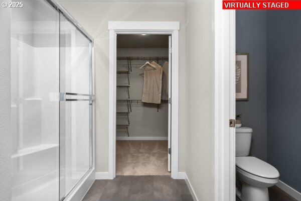 bathroom with toilet and an enclosed shower