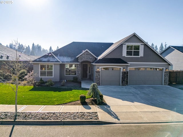 craftsman inspired home with a garage and a front lawn