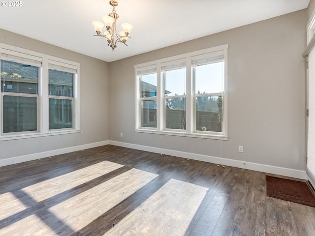 unfurnished room with dark hardwood / wood-style flooring and a chandelier