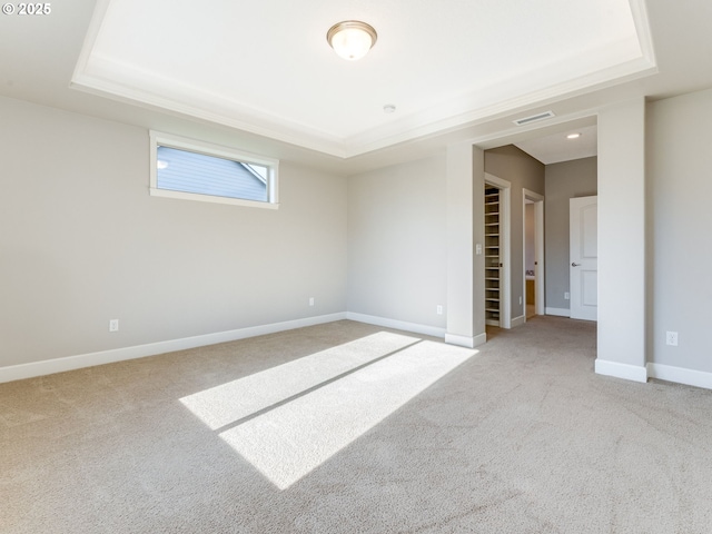 carpeted empty room featuring a raised ceiling