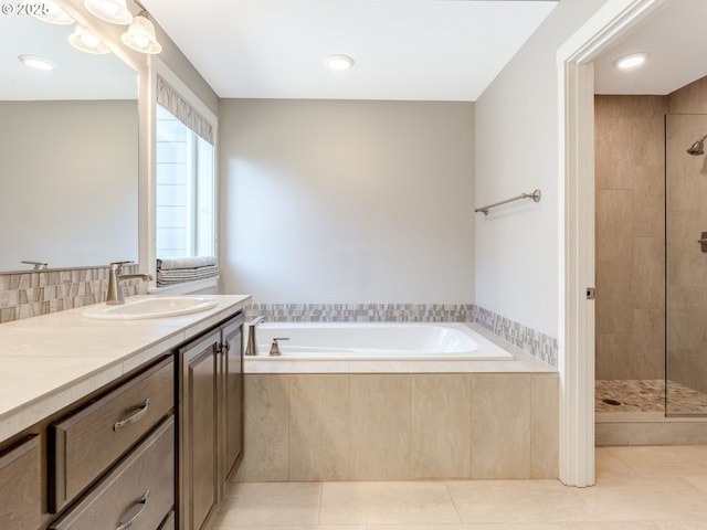 bathroom featuring shower with separate bathtub, tile patterned floors, and vanity